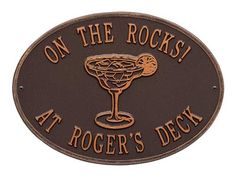 a sign that says on the rocks at roger's deck with a drink in it