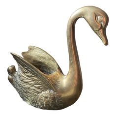 a bronze swan statue sitting on top of a white background