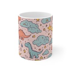 a pink mug with dinosaurs and stars on it