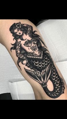 a black and white photo of a woman with a fish tattoo on her leg,