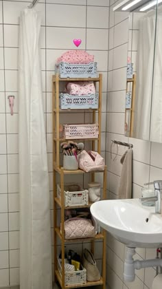 a bathroom with white tile walls and flooring has shelving in the shower area