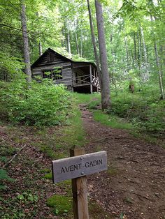 an old log cabin in the woods with a sign that says, avent cabin