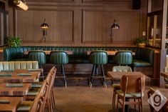 a restaurant with green leather booths and wooden tables