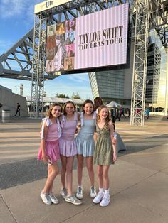 three girls standing in front of a sign at the taylor swift the bears tour event