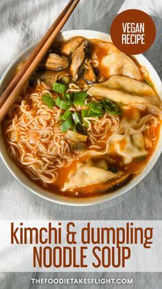 a bowl of kimchi and dumpling noodle soup with chopsticks on the side