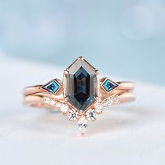 a close up of a ring with a stone and two diamonds on the side,