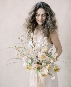 a woman holding a bouquet of flowers in her hands