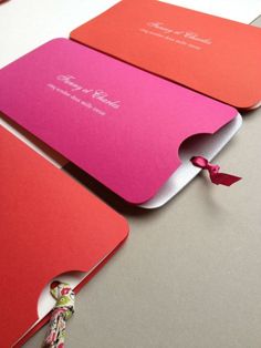 three red and pink folders sitting on top of a table