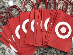 red paper bags with white circles on them sitting on a marble counter top next to each other