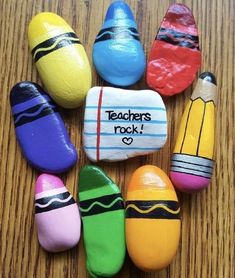 painted rocks that say teachers rock and have pencils in the shape of crayons