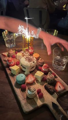 a wooden cutting board topped with lots of desserts