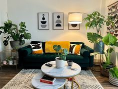 a living room filled with green furniture and potted plants on top of a table