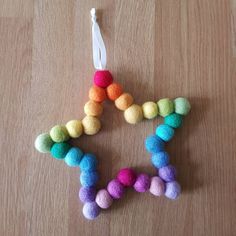 a star ornament made out of pom - poms on a wooden table