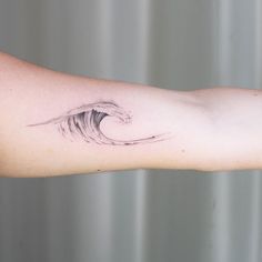 a person's arm with a wave tattoo on it