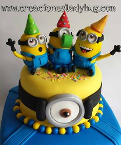 a birthday cake with three minion characters on top