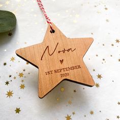 a wooden star ornament with the date and year on it, hanging from a string