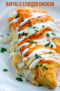 an enchilada covered in cheese and sauce on a white plate with the words buffalo stuffed chicken