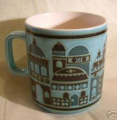 a blue and white coffee cup sitting on top of a table