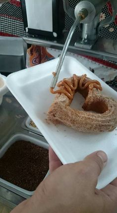 a person is cutting into a doughnut on a paper plate