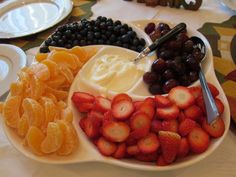 a plate with fruit, yogurt and grapes on it