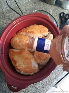 a person is pouring peanut butter into some food in a red bowl on the counter