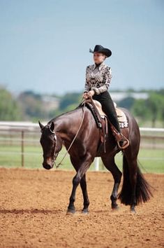 a woman riding on the back of a brown horse