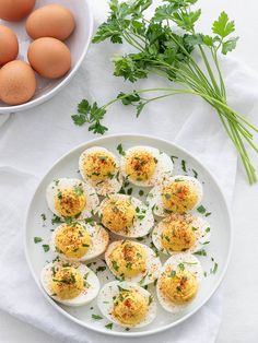 an image of boiled eggs on a plate with parsley in the bowl next to it