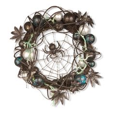 a metal wreath with ornaments and spider webs on it's side, against a white background