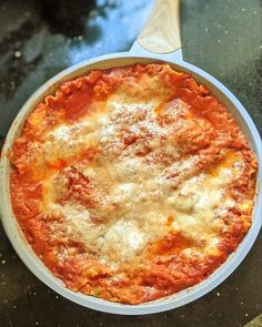 a pan filled with sauce and cheese on top of a table