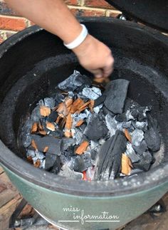 a person is cooking something in a pot on the fire pit with charcoal and wood shavings