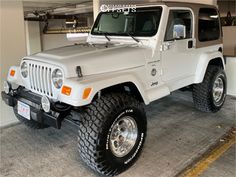 a white jeep is parked in a garage