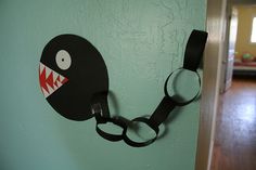 there is a paper cut out of a monster head on the wall next to a pair of scissors