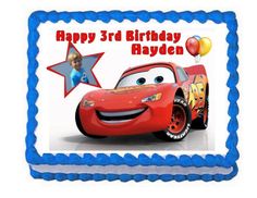 a birthday cake with a photo of the character from cars on it and balloons in the background