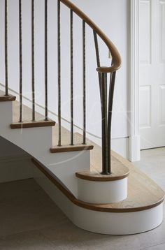 a set of stairs with wooden handrails and white painted walls