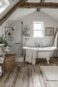 an attic bathroom with white walls and wood floors, a claw foot bathtub in the center