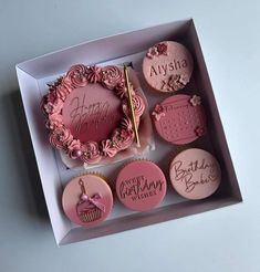 pink cupcakes in a box with happy birthday wishes written on the top and bottom