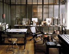 a living room filled with lots of furniture next to a wall covered in glass panels