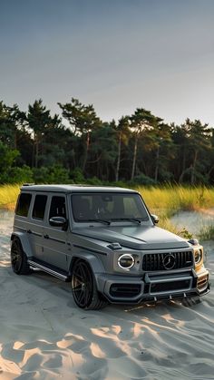 a mercedes g - class is parked in the sand