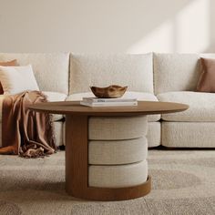 a white couch sitting next to a wooden table on top of a carpeted floor