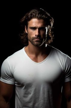 a man with long hair wearing a white t - shirt and looking at the camera