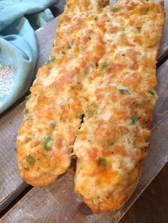 a cheesy bread is sitting on a wooden table