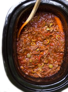 a slow cooker filled with meat and vegetables