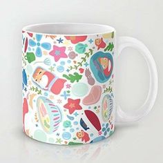 a white coffee mug with colorful cartoon animals on it's side and stars around the edges