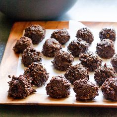 a wooden cutting board topped with chocolate truffles