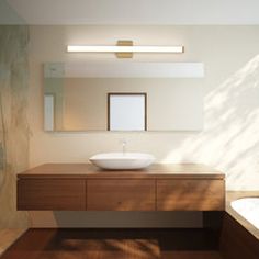 a bathroom with a sink, mirror and bathtub in the middle of the room