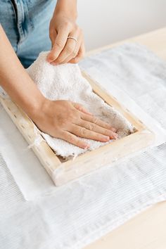 a woman is cleaning the table with a rag