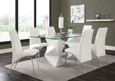 a glass dining table with white chairs around it