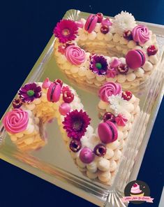 two heart shaped cakes decorated with pink and white frosting on a clear platter