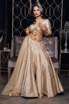 This intricate beauty is such a beautiful array of heritage with a glimpse of a modern day bride! This duo of a radiant Banarsi Silk lehenga and a trendy cut blouse is the perfect go to look for our fashionable divas! #vamadesigns #indianwedding #bollywood #indianbride #lehenga #gold #goldlehenga #punjabiwedding #indianwear#indianfashion #traditionalwear #indianwedding#punjabiwedding #desiwedding #indianbride#bridalwear #bride #sangeet#bridalfashion#bridaloutfit#weddingoutfit #bridal #golden Festive Dola Silk Lehenga With Intricate Embroidery, Festive Kundan Lehenga With Zari Work, Elegant Art Silk Choli With Intricate Embroidery, Festive Raw Silk Lehenga With Zari Work, Bollywood Festive Gown With Intricate Embroidery, Bollywood Style Festive Gown With Intricate Embroidery, Festive Bollywood Gown With Intricate Embroidery, Festive Lehenga With Resham Embroidery, Unstitched Dola Silk Lehenga With Intricate Embroidery