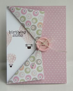 a birthday card with an origami hot air balloon on the front and pink button in the middle